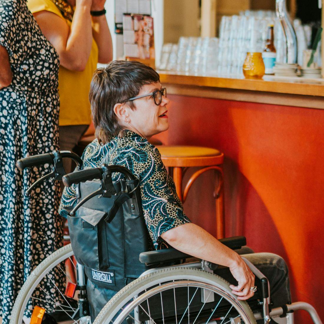 Photo of two people in wheelchairs at the bar