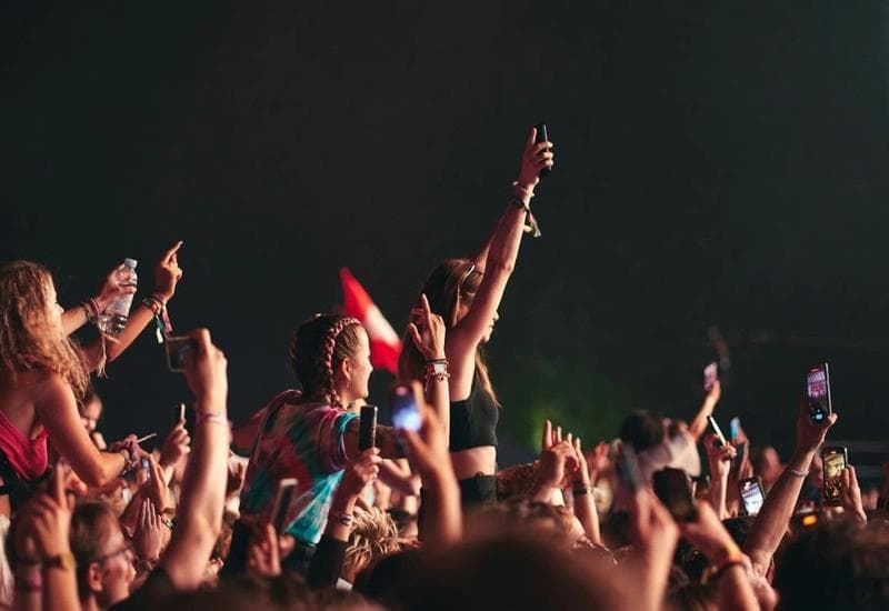 Young people in an audience standing and cheering.