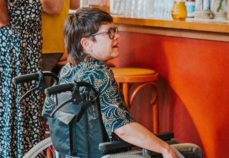 Photo of two people in wheelchairs at the bar