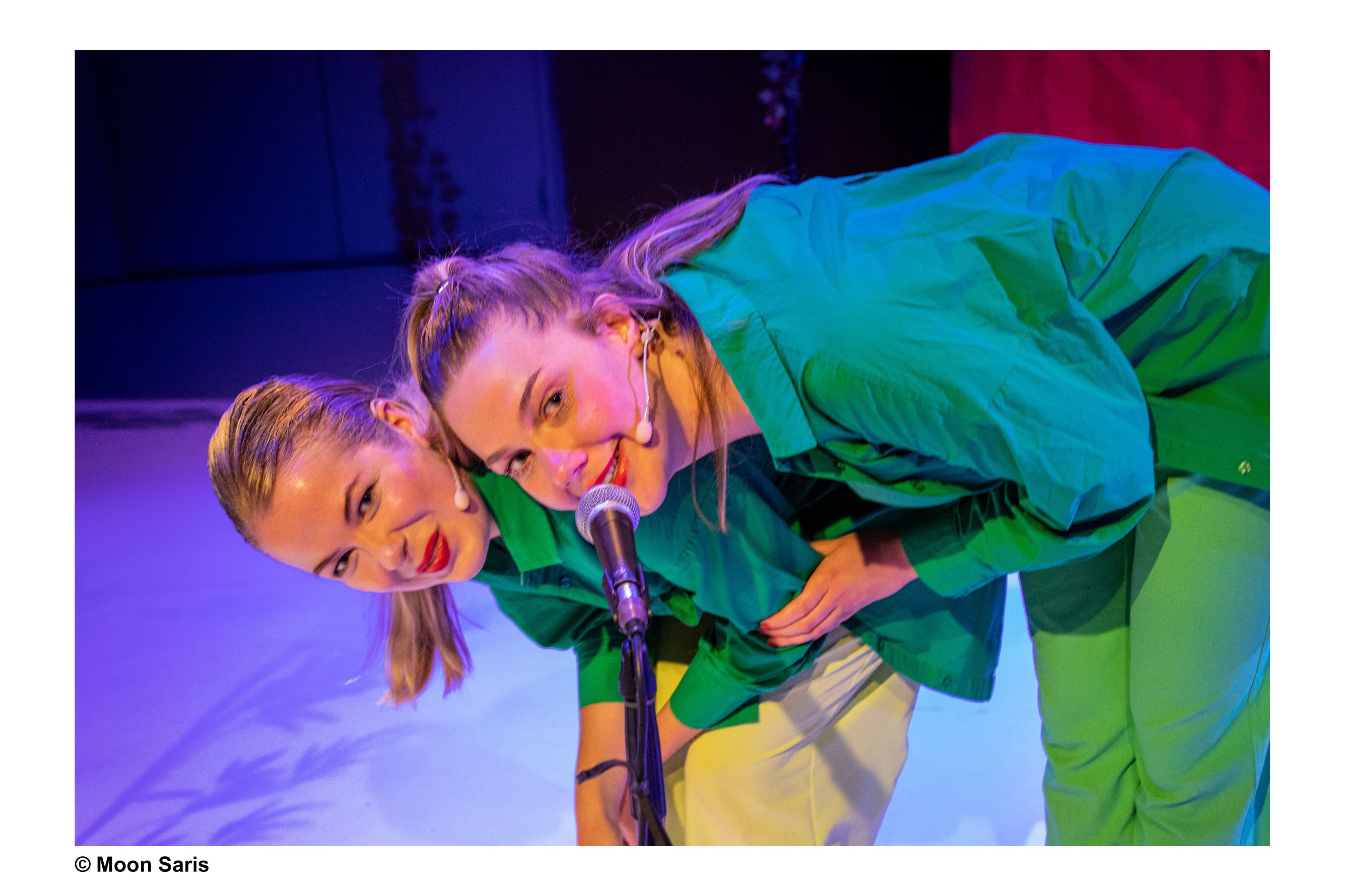 Twee actrices op een podium omhelzen elkaar